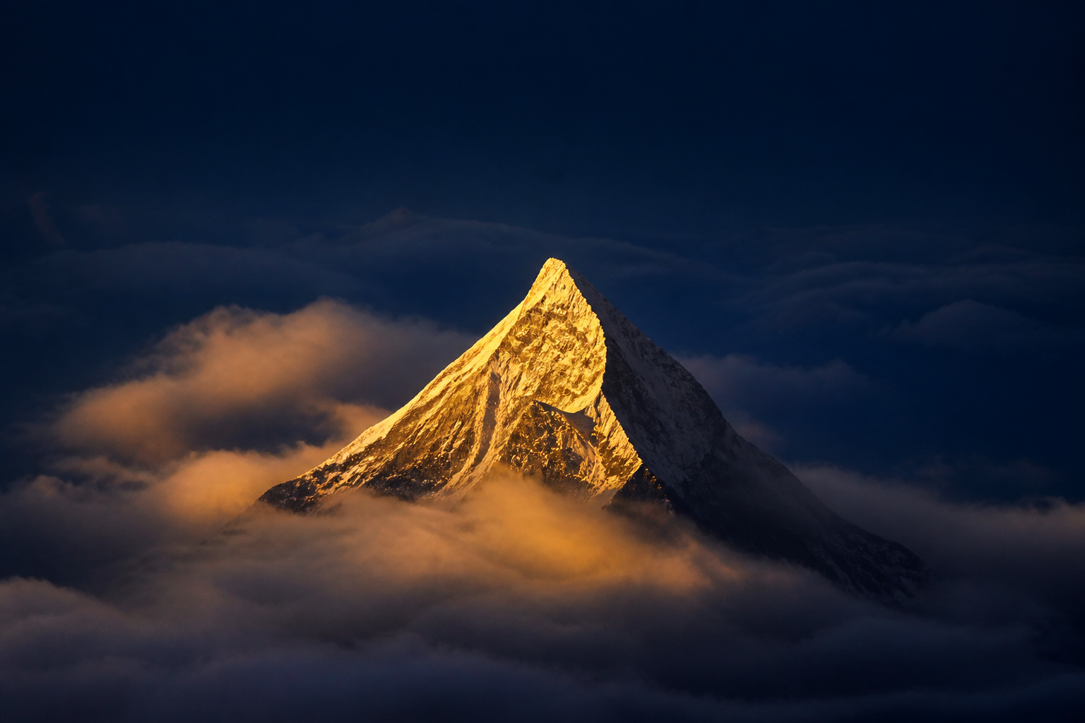 A single golden summit peak catching first light above the clouds